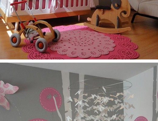 habitación para recién nacido en gris y rosa, con guirnalda de mariposas y cuna blanca, juguetes de madera alfombras rosas